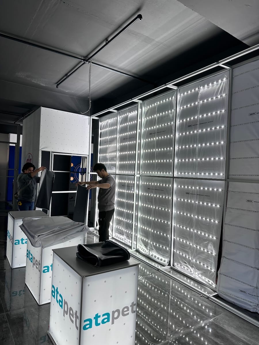 Etkinlik alanında modüler lightbox stand kurulumu yapan personel